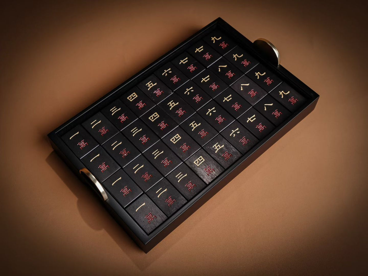 Handcrafted dark wooden mahjong tiles in a tray